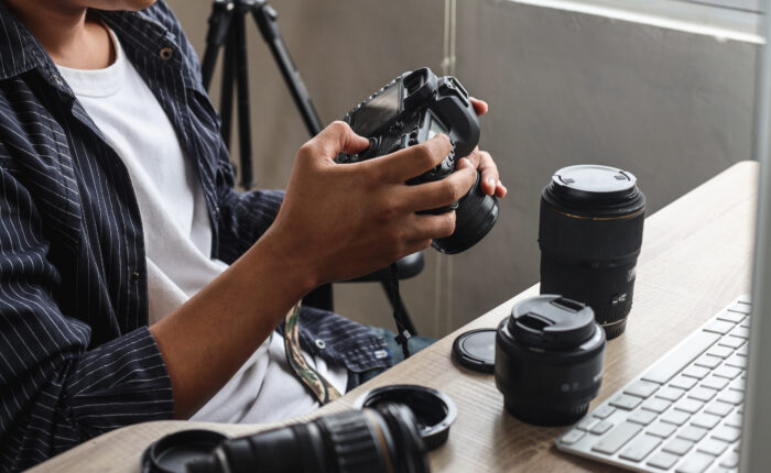 Young man photographer sitting and press button of professional