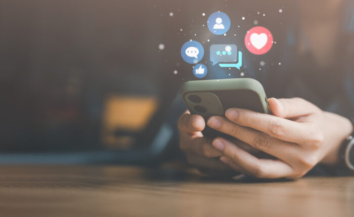 Social media and digital online concept, woman using smart phone on sofa at home. The concept of living on vacation and playing social media.