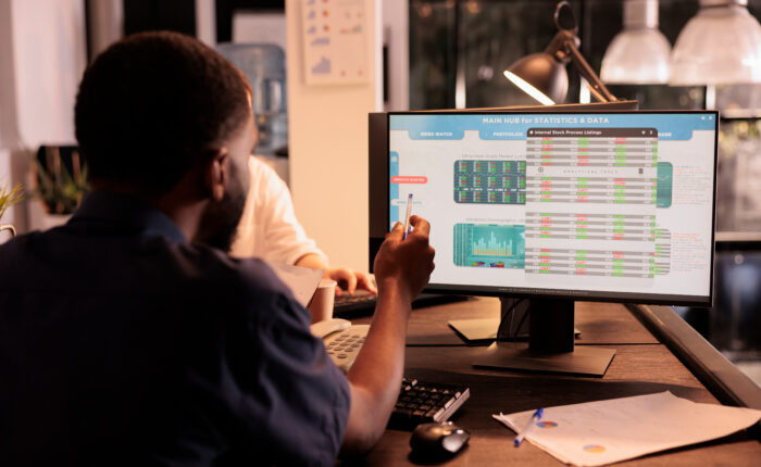 Employee analyzing global fund market investment statistics on computer